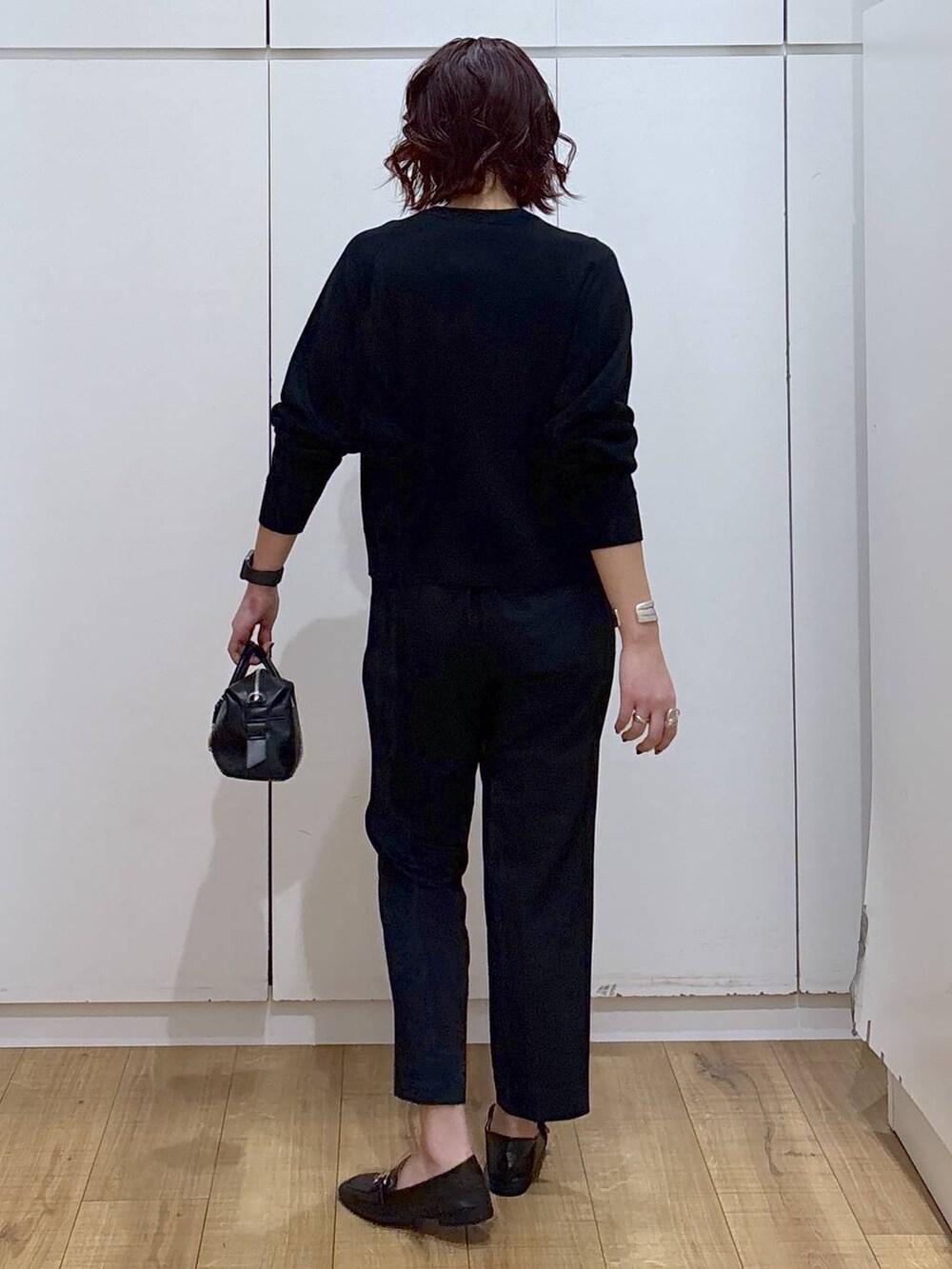 ブラック系のローファー、ブルー系のスラックス、ブラック系のカーディガン/ボレロを着用したレディースの春コーディネートの6枚目の写真