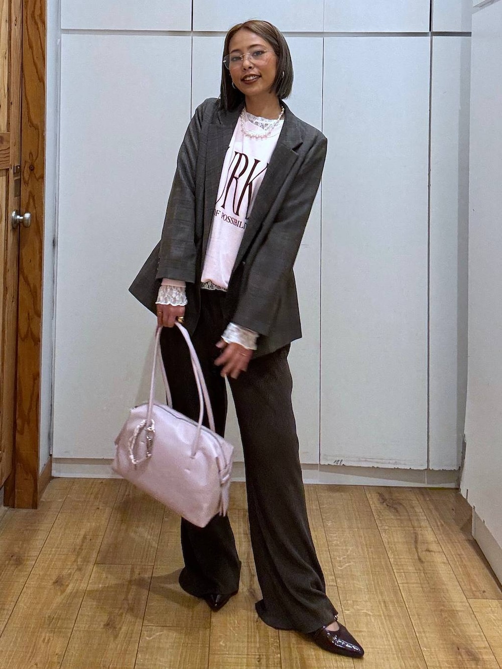 パープル系のボストンバッグ、ホワイト系のTシャツ/カットソー、ブラウン系のテーラードジャケットを着用したレディースの秋コーディネートの3枚目の写真