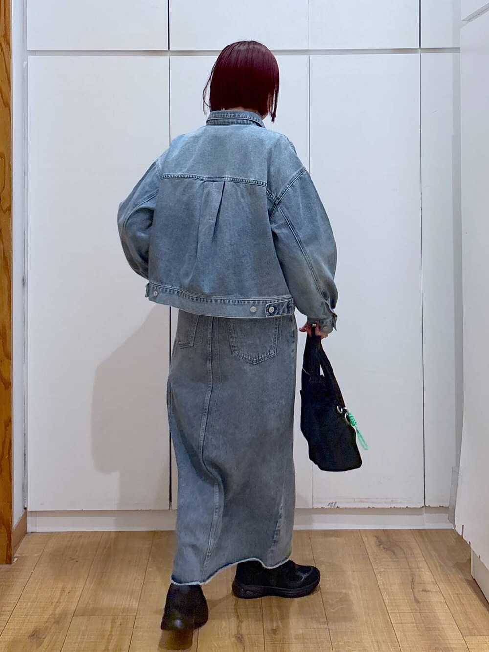 ブルー系のスカート、ブルー系のデニムジャケット、ブラック系のスニーカーを着用したレディースの春コーディネートの5枚目の写真