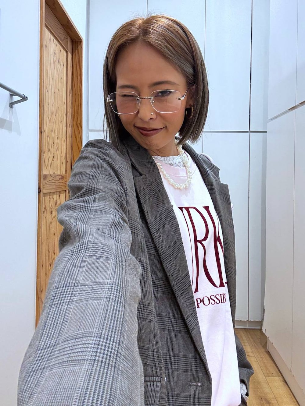 パープル系のボストンバッグ、ホワイト系のTシャツ/カットソー、ブラウン系のテーラードジャケットを着用したレディースの秋コーディネートの9枚目の写真