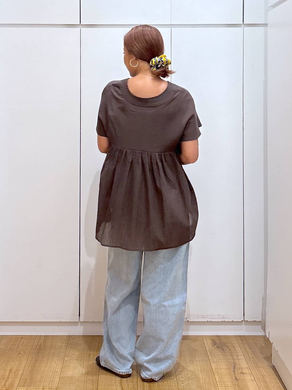 ブルー系のデニムパンツ、ブラック系のキャミソール、イエロー系のブレスレットを着用したレディースの夏コーディネートの3枚目の写真