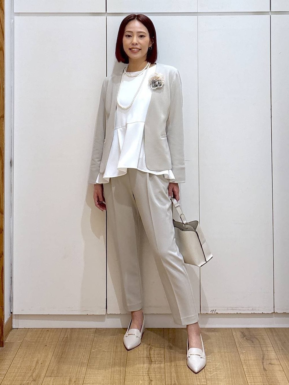 ベージュ系のセットアップ、ベージュ系のショルダーバッグ、ホワイト系のローファーを着用したレディースの春コーディネートの3枚目の写真