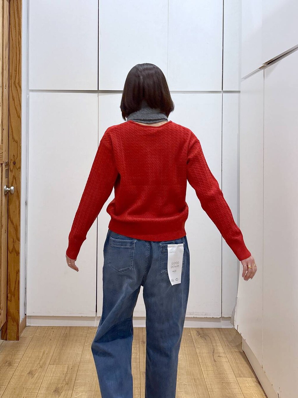 ブルー系のチェスターコート、ブラック系のブーツ、ブルー系のデニムパンツを着用したレディースの秋コーディネートの7枚目の写真