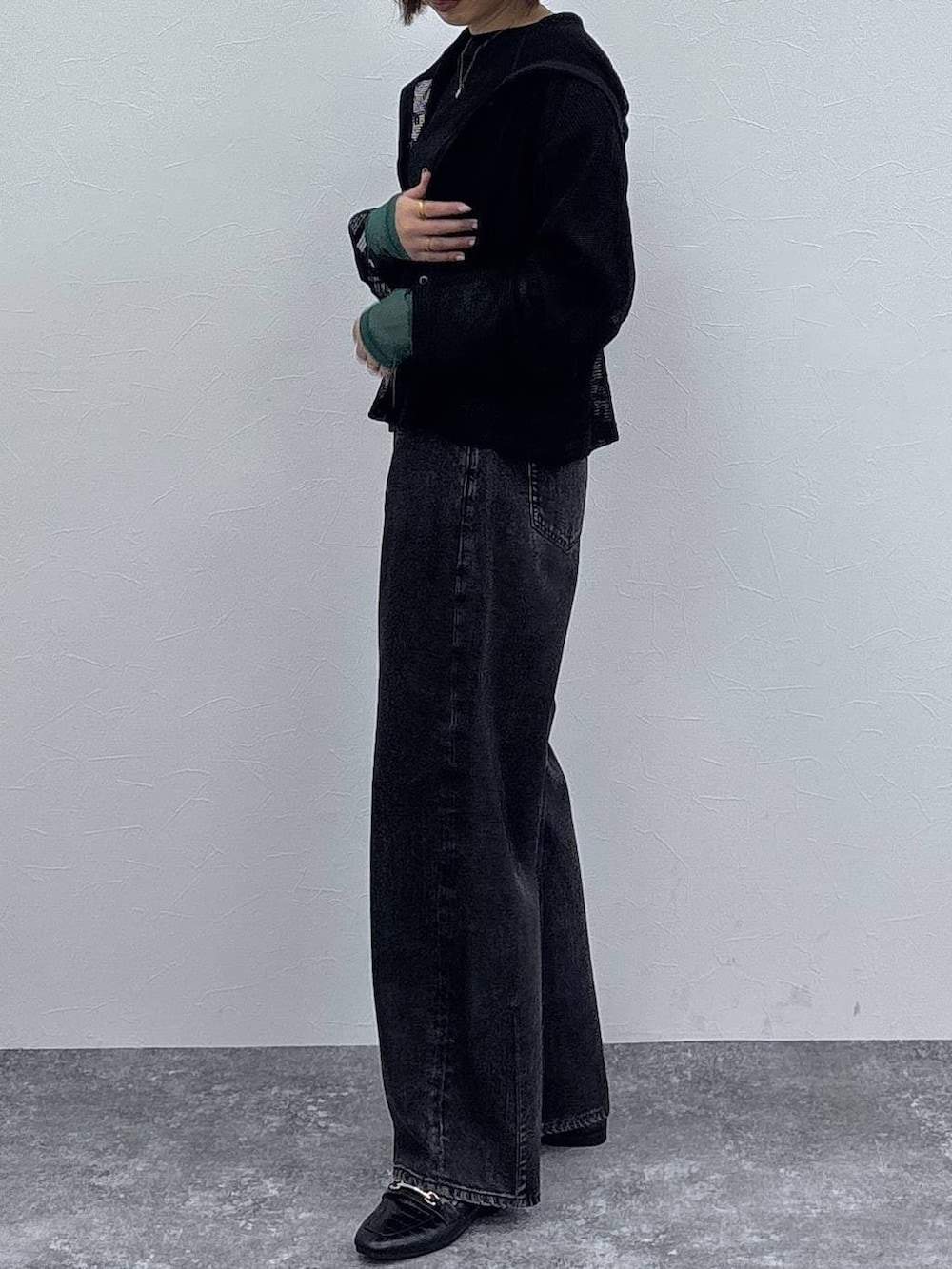 ブラック系のローファー、ブラック系のパーカー、ゴールド系のネックレスを着用したレディースの春コーディネートの4枚目の写真