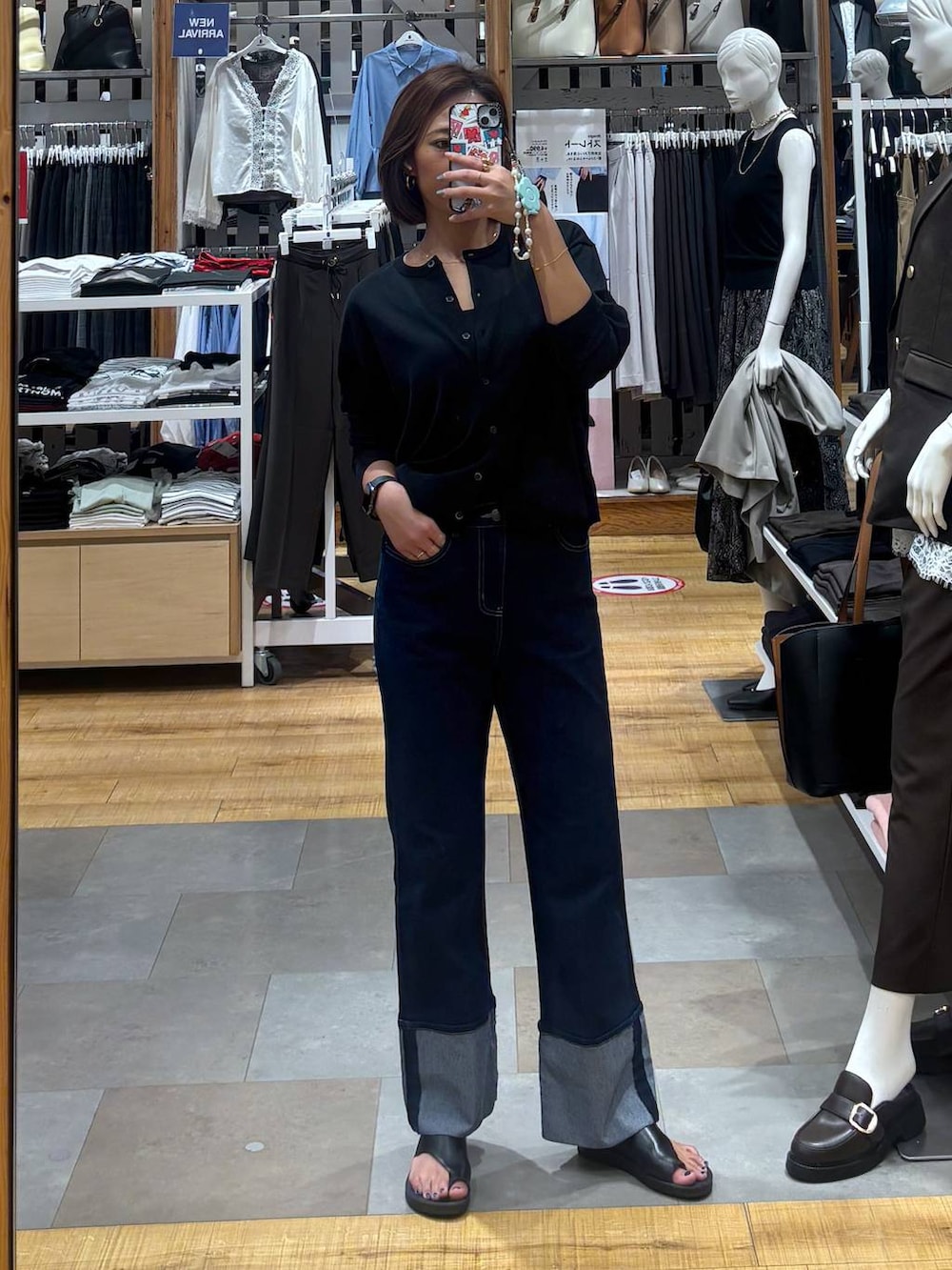 ブルー系のデニムパンツ、ブラック系のキャミソール、ブラック系のカーディガン/ボレロを着用したレディースの夏コーディネートの3枚目の写真