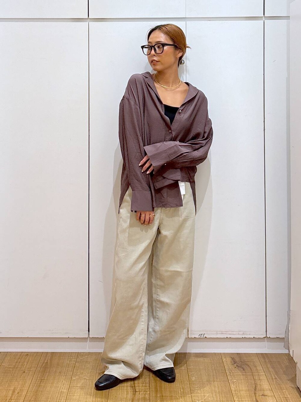 ブラック系のローファー、ブラック系のキャミソール、ベージュ系のデニムパンツを着用したレディースの秋コーディネートの2枚目の写真