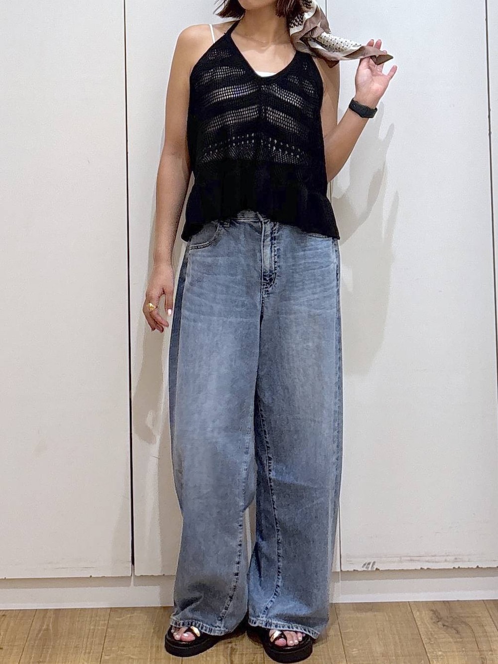 ホワイト系のキャミソール、ブルー系のデニムパンツ、ブラック系のサンダルを着用したレディースの春コーディネートの2枚目の写真