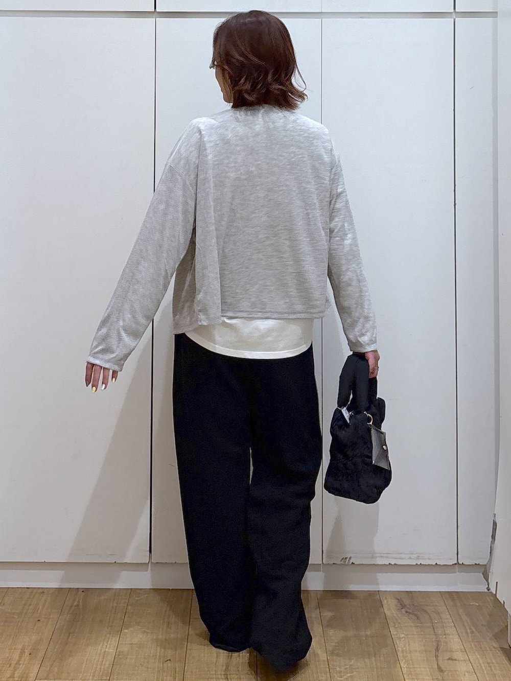 ブラック系のトートバッグ、ブラック系のその他パンツ、ホワイト系のTシャツ/カットソーを着用したレディースの春コーディネートの3枚目の写真