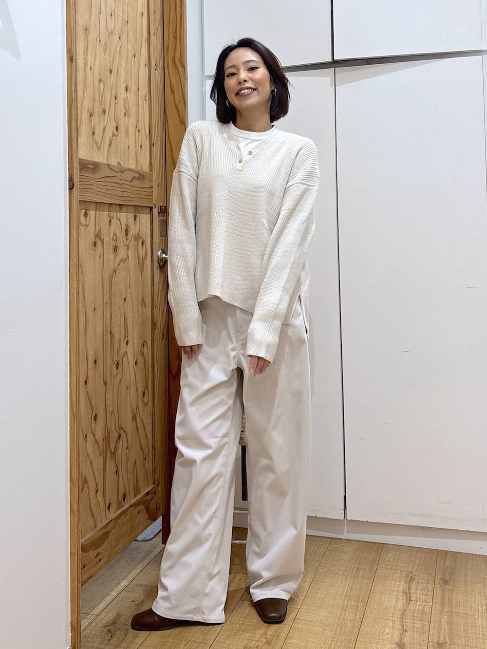 グレー系のその他パンツ、ベージュ系のニット/セーター、ブラウン系のブーツを着用したレディースの秋コーディネートの2枚目の写真