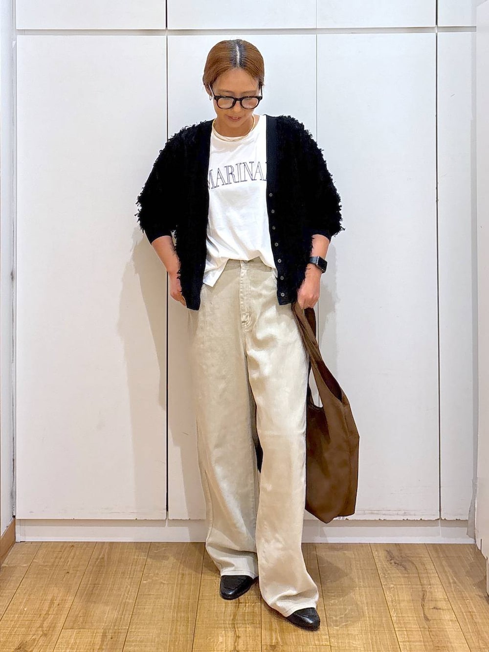 ブラック系のローファー、ホワイト系のTシャツ/カットソー、ベージュ系のデニムパンツを着用したレディースの秋コーディネートの3枚目の写真