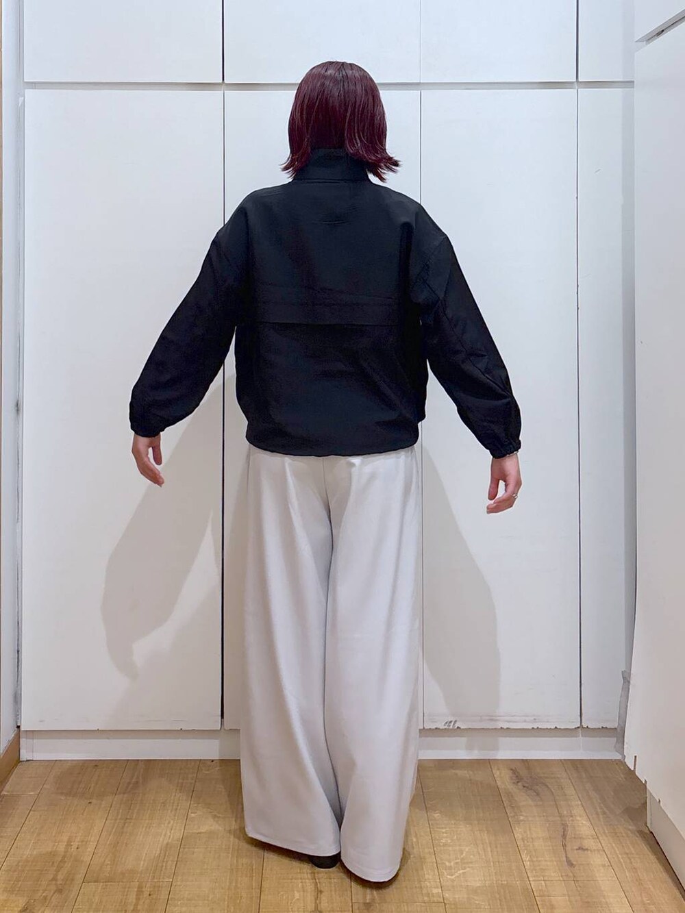 ベージュ系のトレンチコート、グレー系のその他パンツ、ホワイト系のブルゾンを着用したレディースの春コーディネートの8枚目の写真