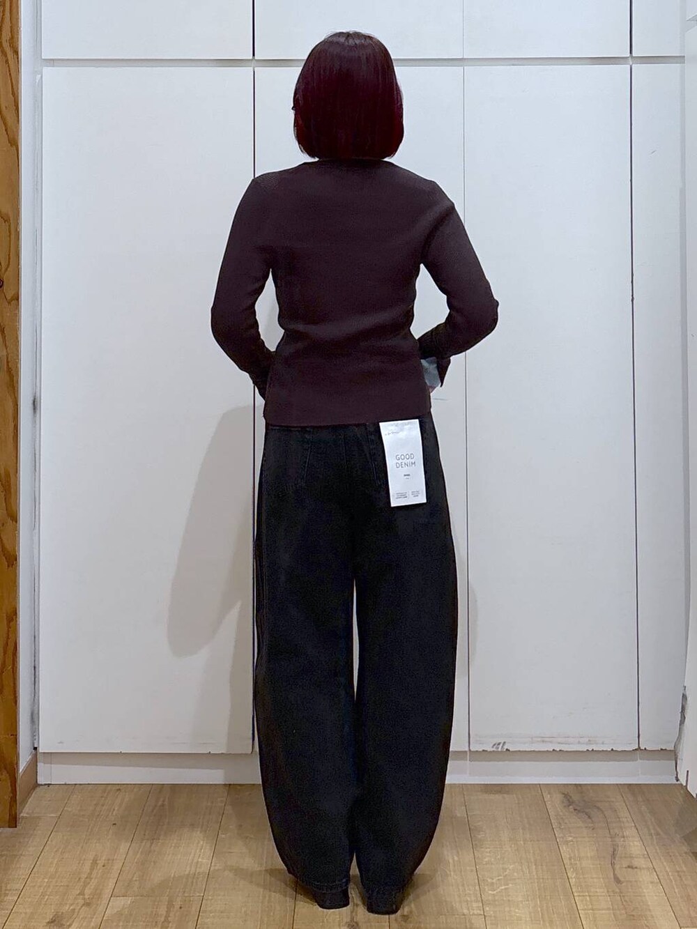 ブラック系のブーツ、ブラック系のデニムパンツ、ブラウン系のニット/セーターを着用したレディースの春コーディネートの4枚目の写真