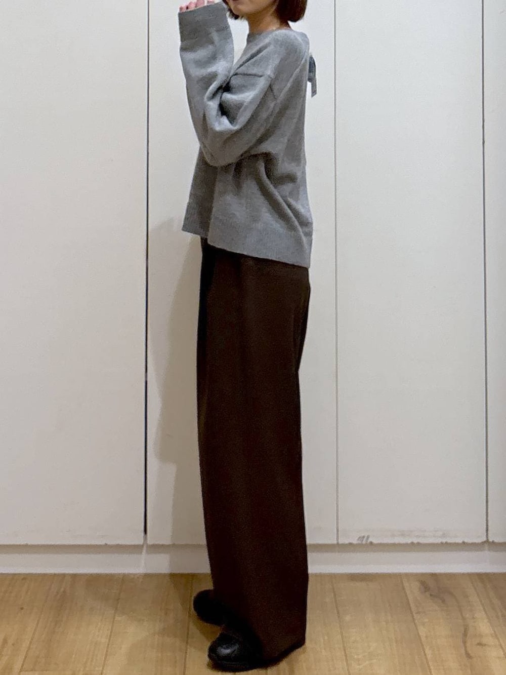 ブラック系のスニーカー、ブラウン系のその他パンツ、ゴールド系のピアス（両耳用）を着用したレディースの冬コーディネートの3枚目の写真