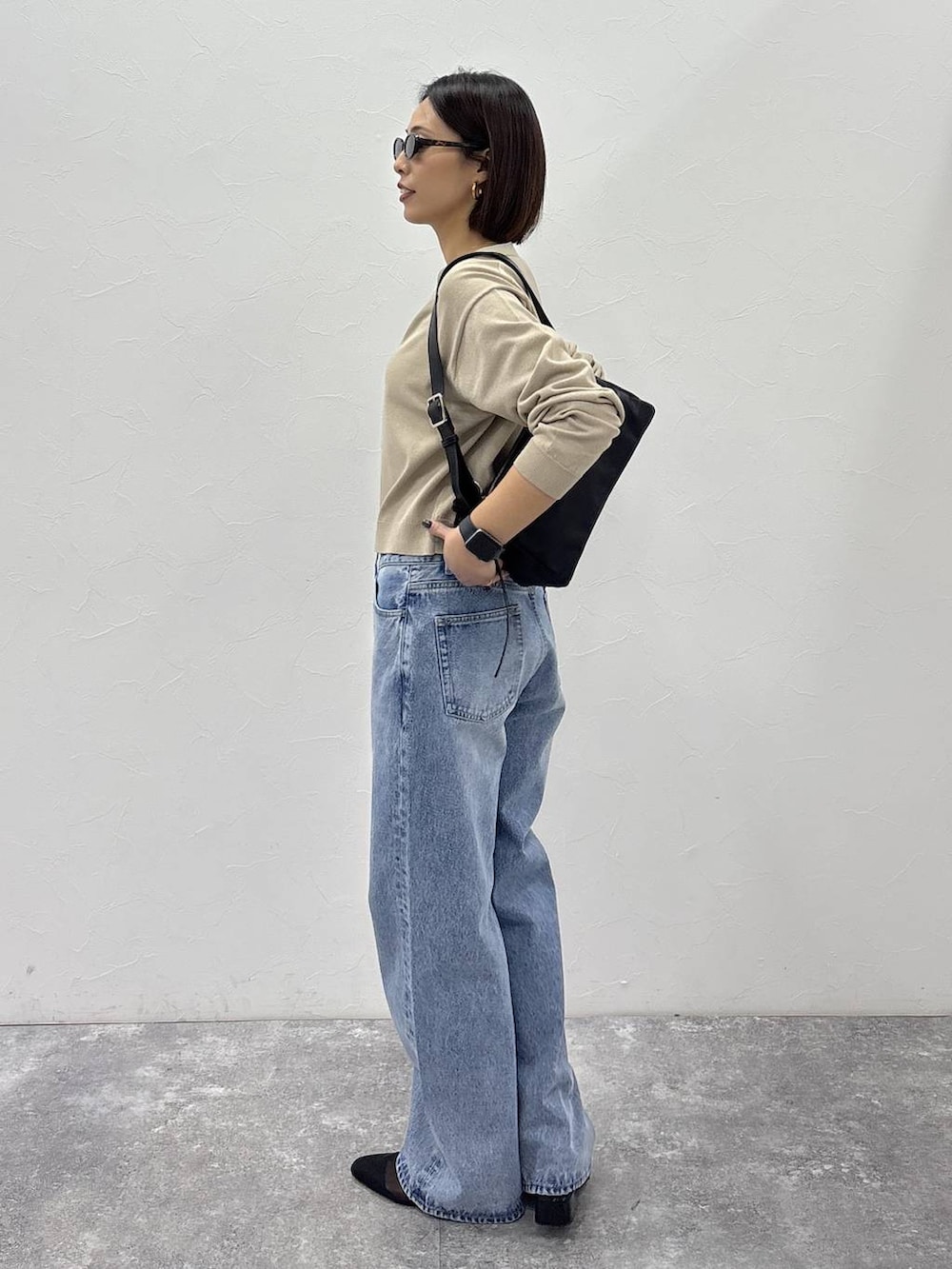 ブラック系のショルダーバッグ、ゴールド系のピアス（両耳用）、ゴールド系のリングを着用したレディースの冬コーディネートの5枚目の写真