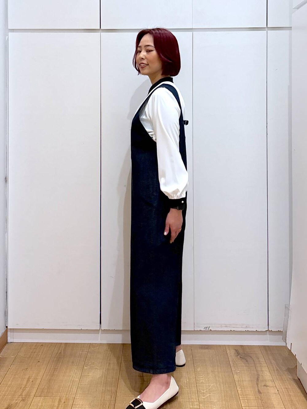 ホワイト系のシャツ/ブラウス、ブルー系のサロペット/オーバーオール、ホワイト系のパンプスを着用したレディースの春コーディネートの3枚目の写真