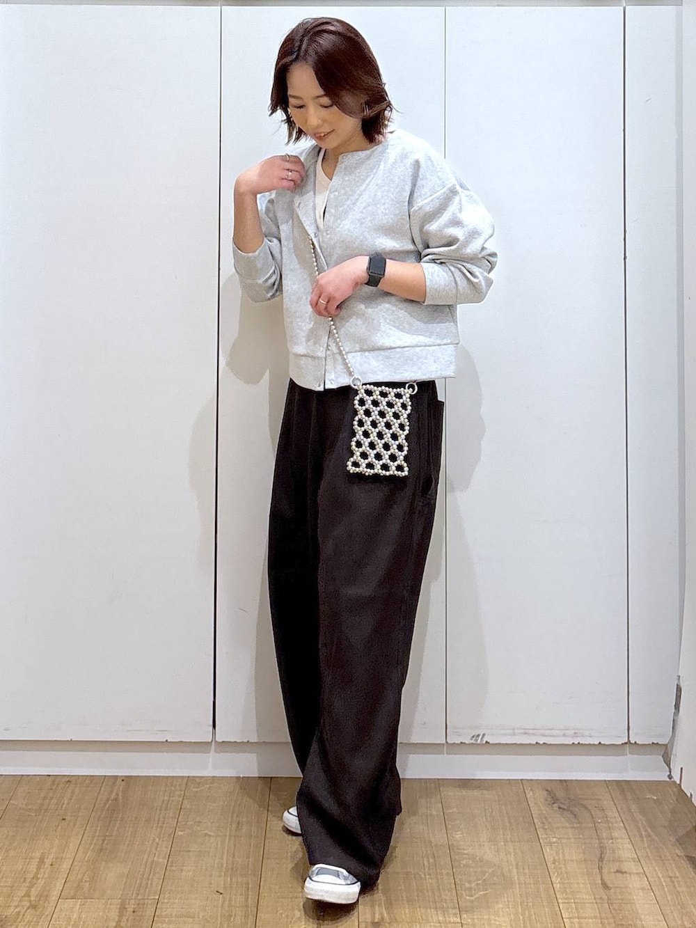 グレー系のカーディガン/ボレロ、ブラウン系のその他パンツ、ホワイト系のタンクトップを着用したレディースの春コーディネートの4枚目の写真