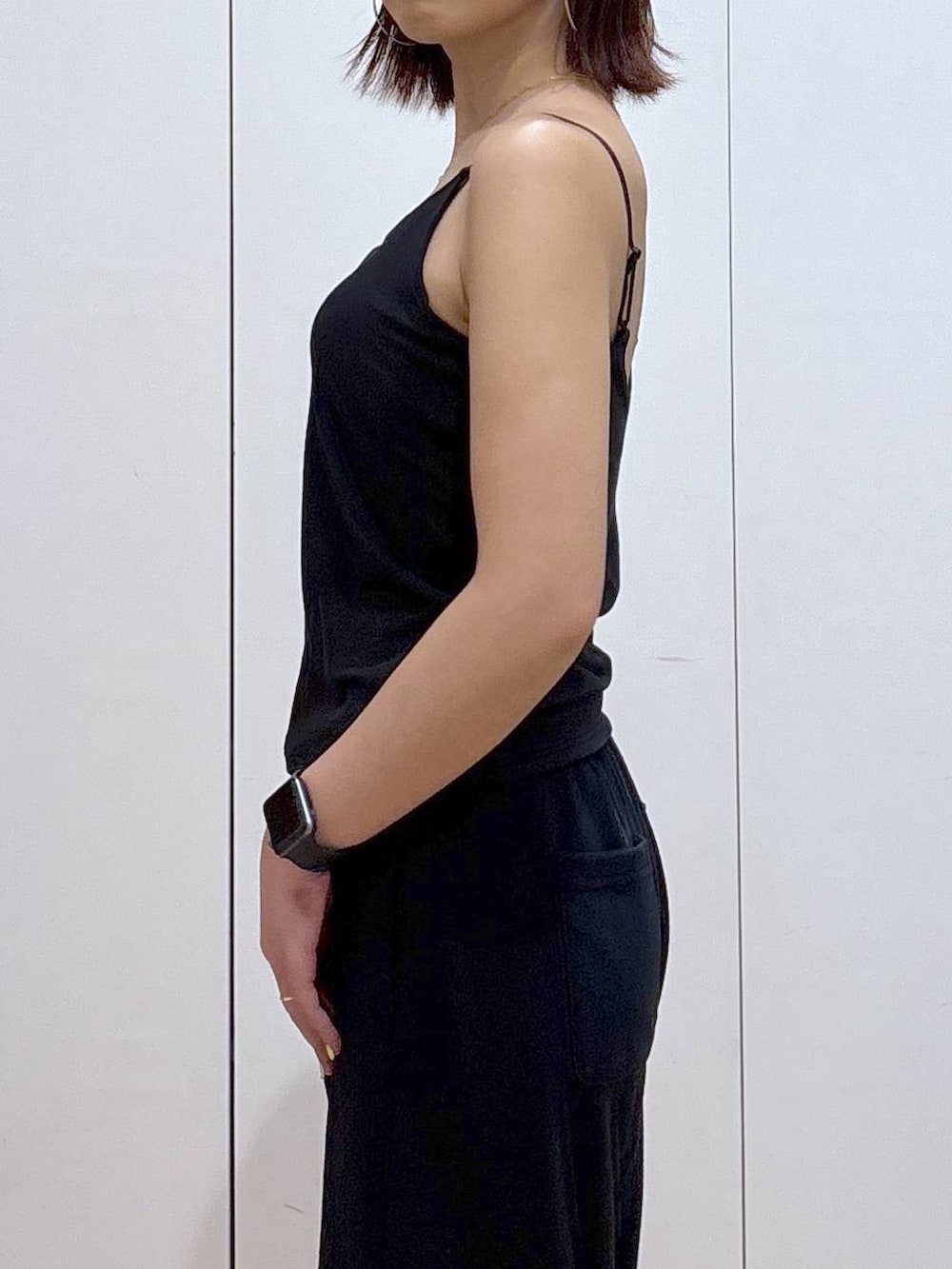 ブラック系のキャミソール、ブラック系のスウェットパンツ、ゴールド系のネックレスを着用したレディースの春コーディネートの4枚目の写真