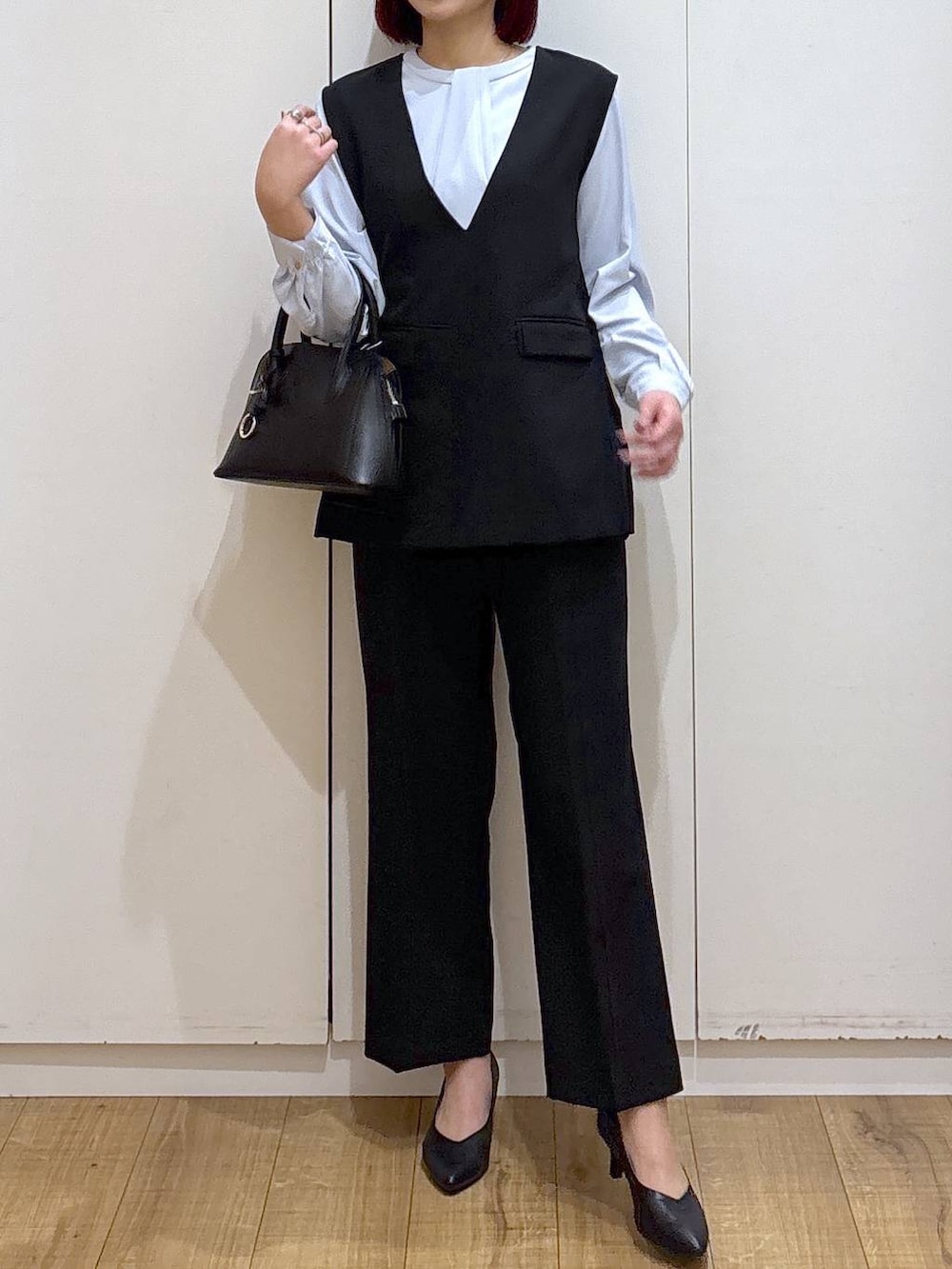 ブラック系のショルダーバッグ、ブラック系のパンプス、ブルー系のシャツ/ブラウスを着用したレディースの春コーディネートの3枚目の写真