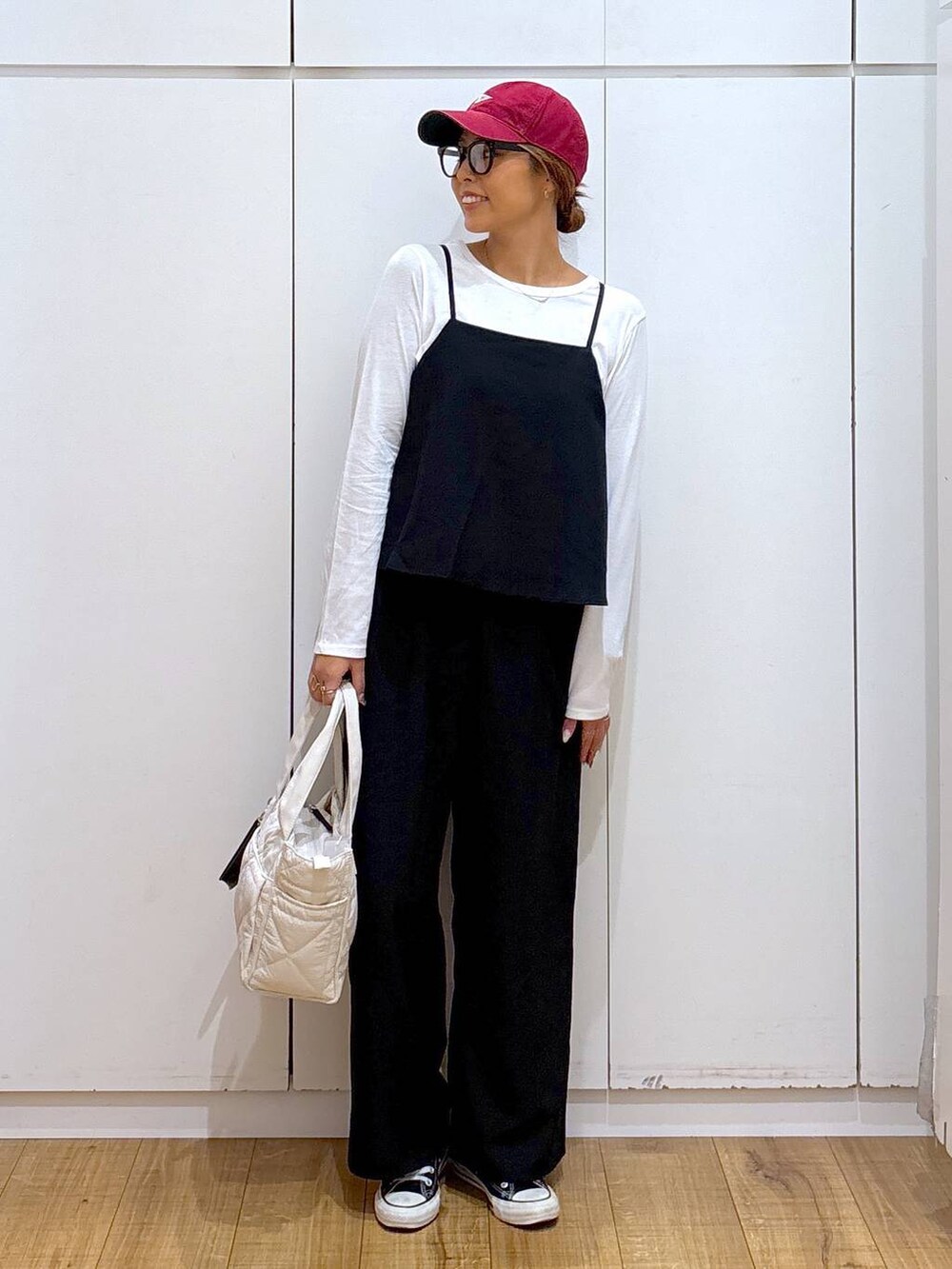 ホワイト系のトートバッグ、ブラック系のサロペット/オーバーオール、ブラック系のサングラスを着用したレディースの秋コーディネートの4枚目の写真