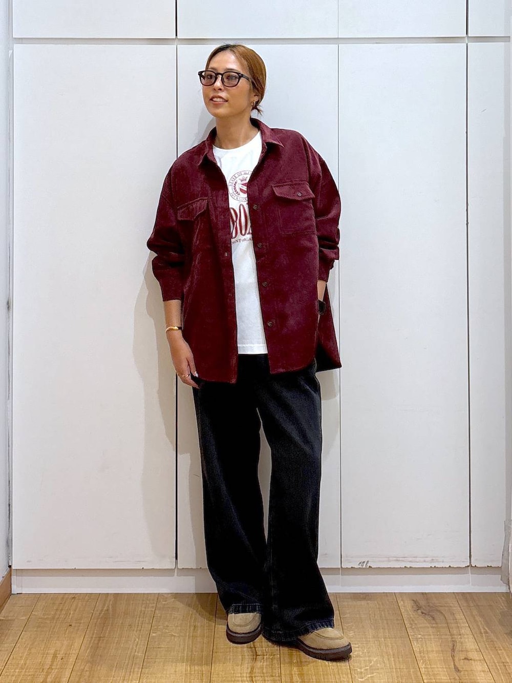 ブラック系のデニムパンツ、レッド系のシャツ/ブラウス、ベージュ系のローファーを着用したレディースの秋コーディネートの3枚目の写真