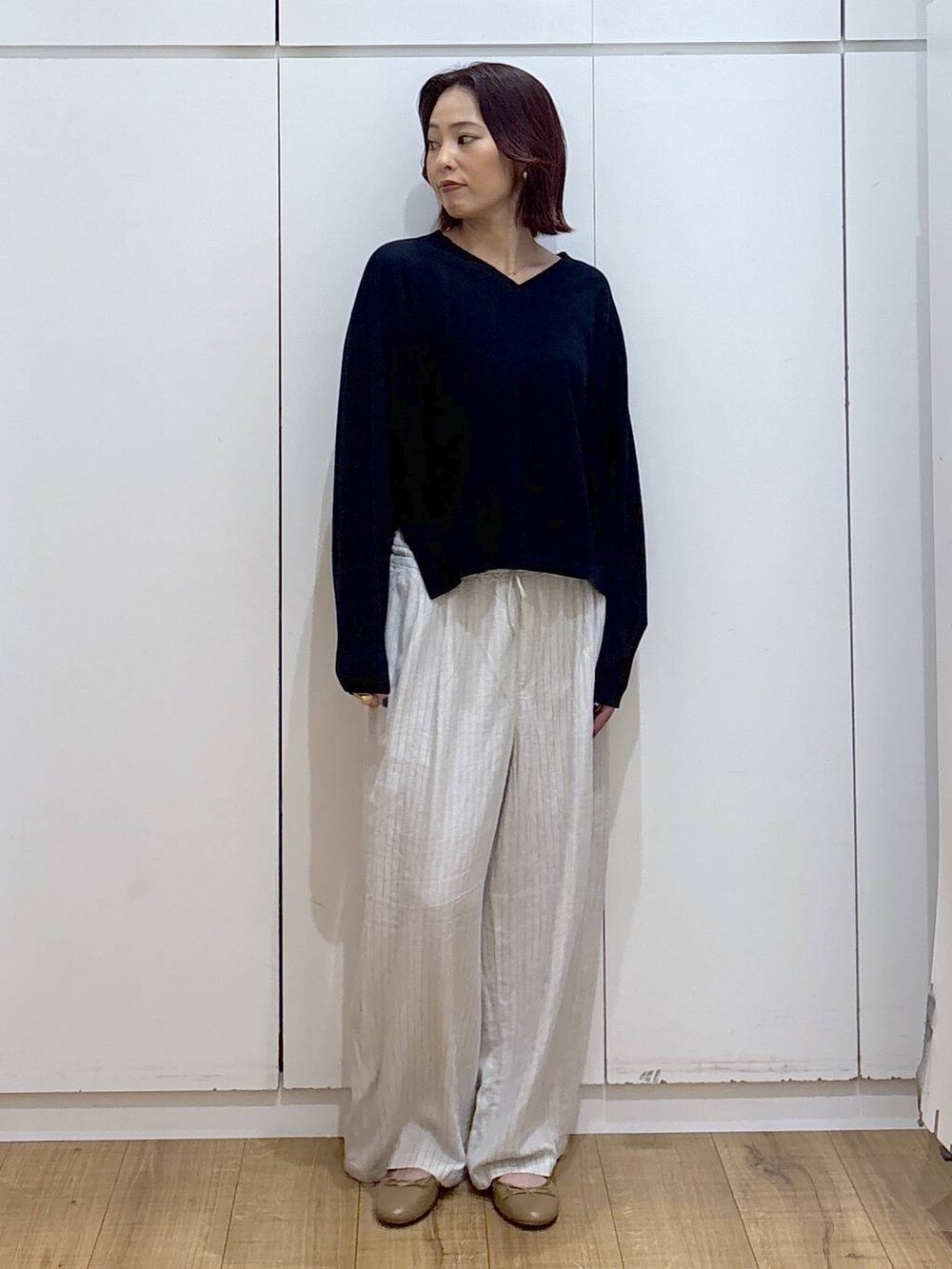 ブラウン系のバレエシューズ、ベージュ系のその他パンツ、ブルー系のニット/セーターを着用したレディースの春コーディネートの2枚目の写真