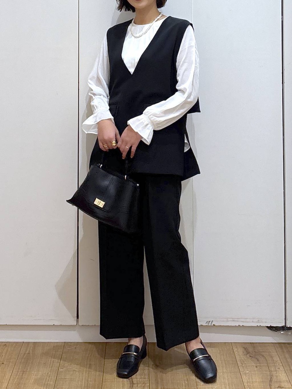 ブラック系のローファー、ブラック系のセットアップ、ブラック系のショルダーバッグを着用したレディースの冬コーディネートの8枚目の写真