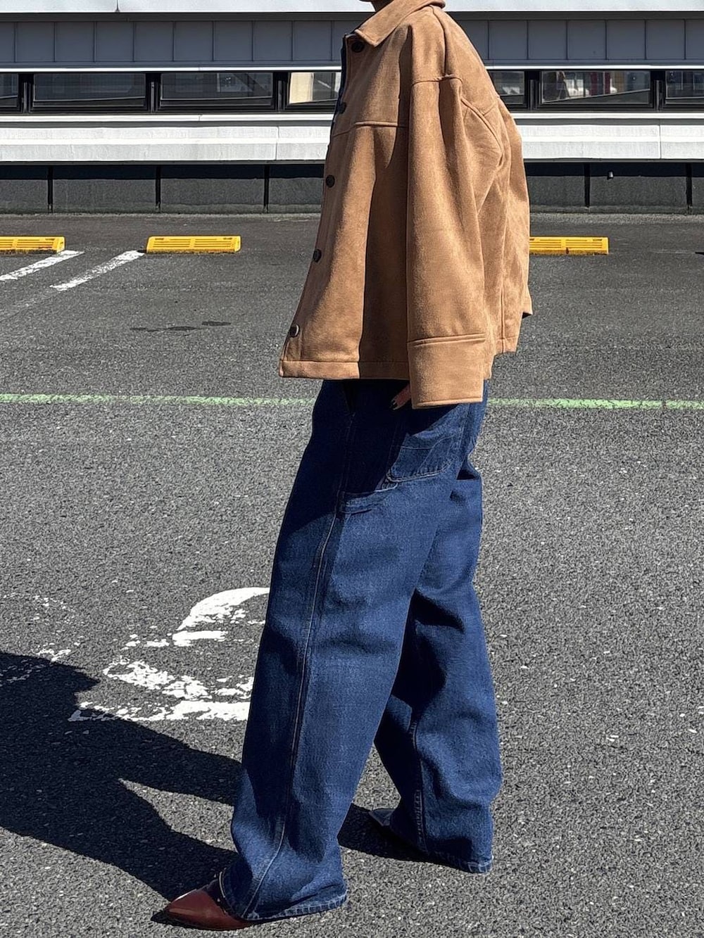 ブルー系のデニムジャケット、ブラウン系のテーラードジャケット、ブルー系のデニムパンツを着用したレディースの冬コーディネートの5枚目の写真