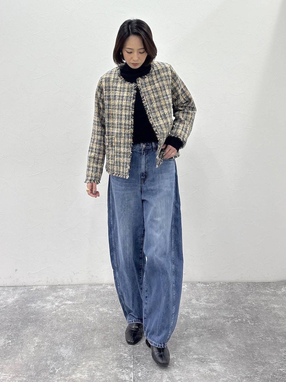 ブラック系のニット/セーター、ブラック系のブーツ、ブルー系のデニムパンツを着用したレディースの冬コーディネートの4枚目の写真