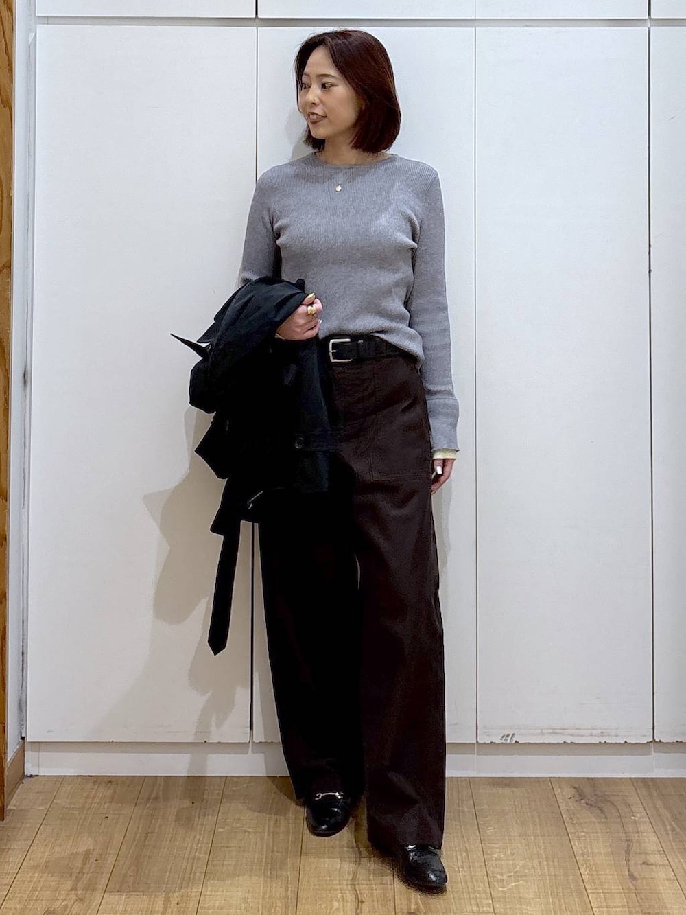 ブラック系のローファー、ブルー系のトレンチコート、グレー系のニット/セーターを着用したレディースの春コーディネートの4枚目の写真