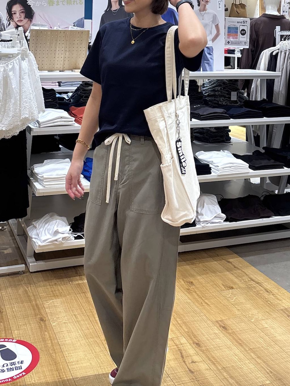 ベージュ系のトートバッグ、ブルー系のTシャツ/カットソー、グリーン系のその他パンツを着用したレディースの春コーディネートの4枚目の写真