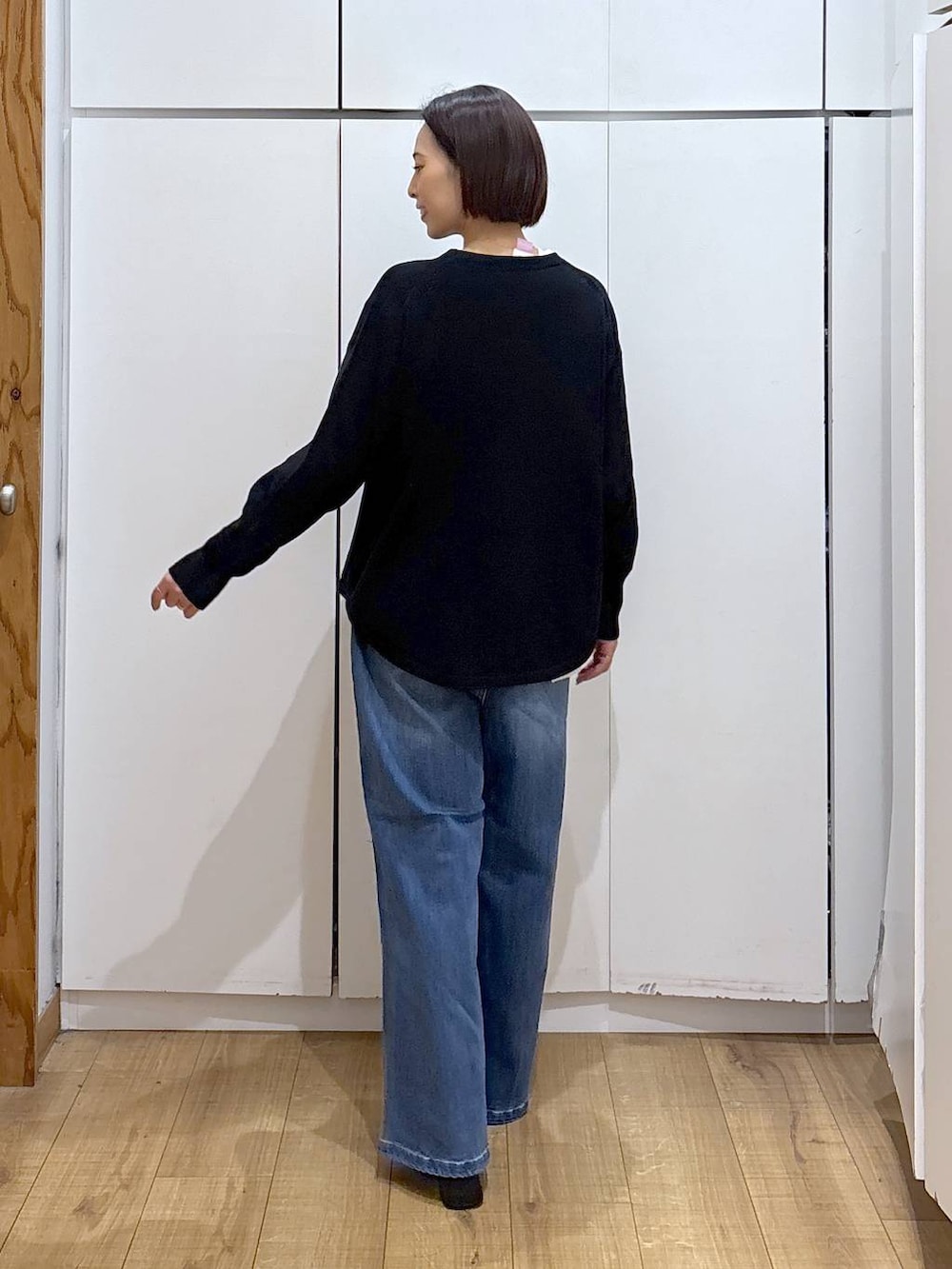 ブラック系のニット/セーター、ブラウン系のダウンジャケット/コート、ホワイト系のTシャツ/カットソーを着用したレディースの冬コーディネートの7枚目の写真