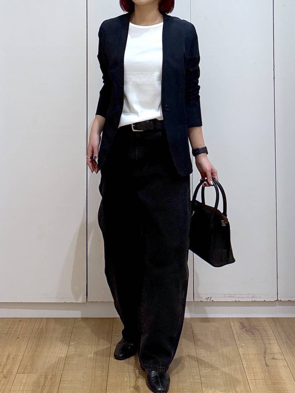 ブラック系のショルダーバッグ、ブラック系のブーツ、ブルー系のノーカラージャケットを着用したレディースの春コーディネートの4枚目の写真