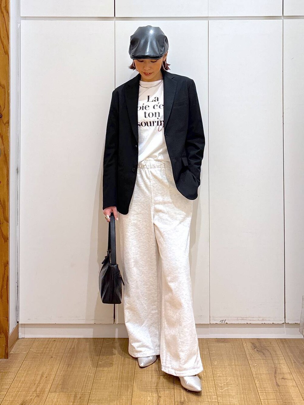 ブラック系のテーラードジャケット、ブラック系のショルダーバッグ、ホワイト系のTシャツ/カットソーを着用したレディースの春コーディネートの4枚目の写真