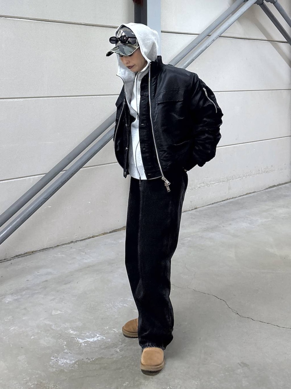 ブラック系のデニムパンツ、ブラック系のデニムジャケット、グレー系のパーカーを着用したレディースの冬コーディネートの3枚目の写真