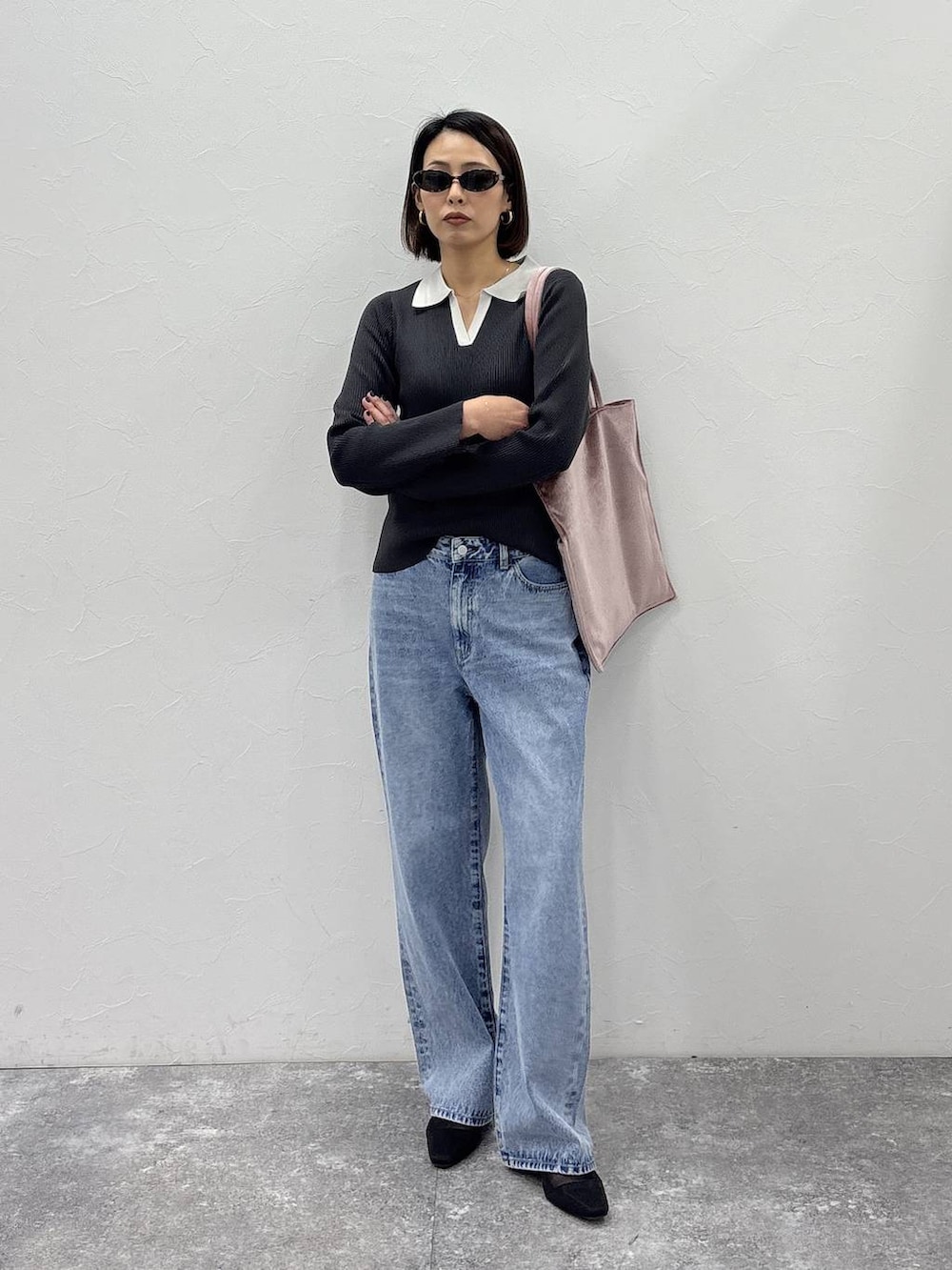 ピンク系のトートバッグ、グレー系のニット/セーター、ゴールド系のピアス（両耳用）を着用したレディースの冬コーディネートの2枚目の写真