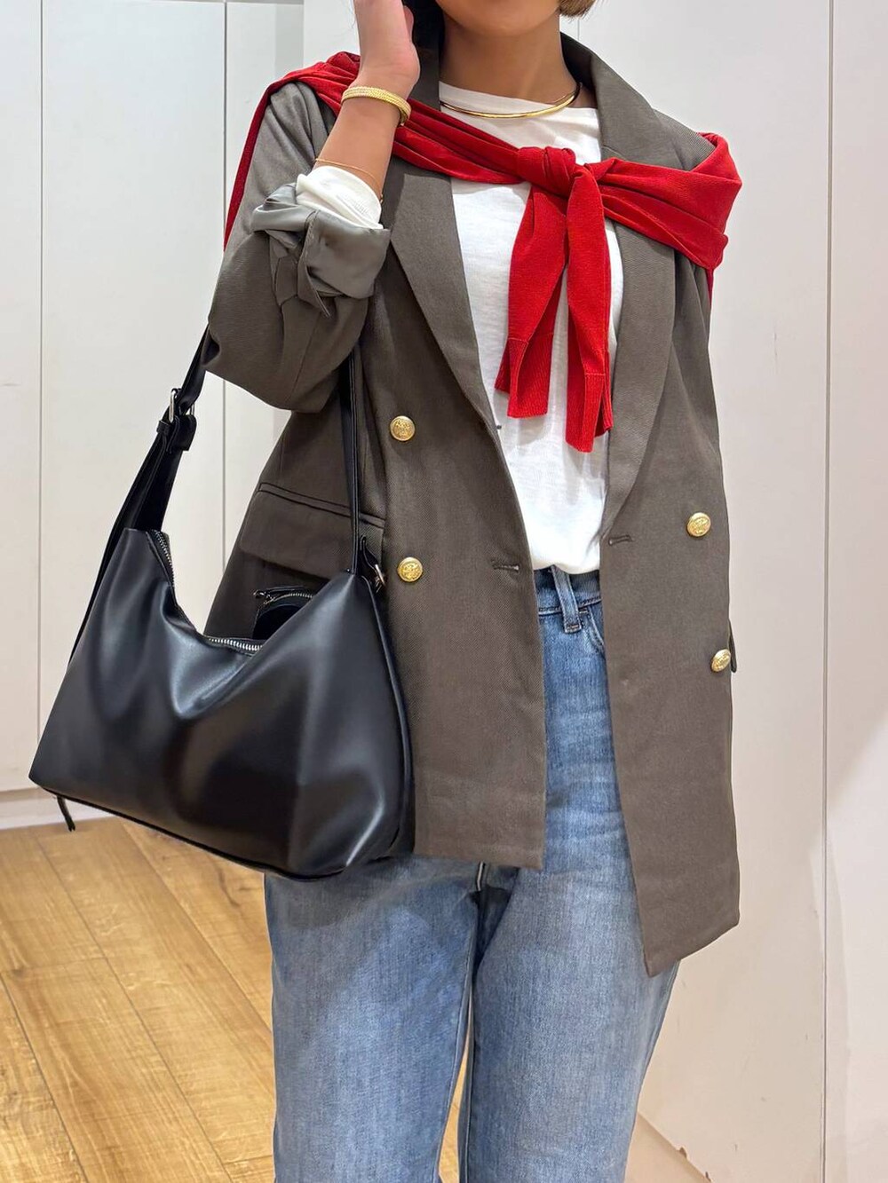 レッド系のカーディガン/ボレロ、ホワイト系のTシャツ/カットソー、ブルー系のデニムパンツを着用したレディースの秋コーディネートの9枚目の写真