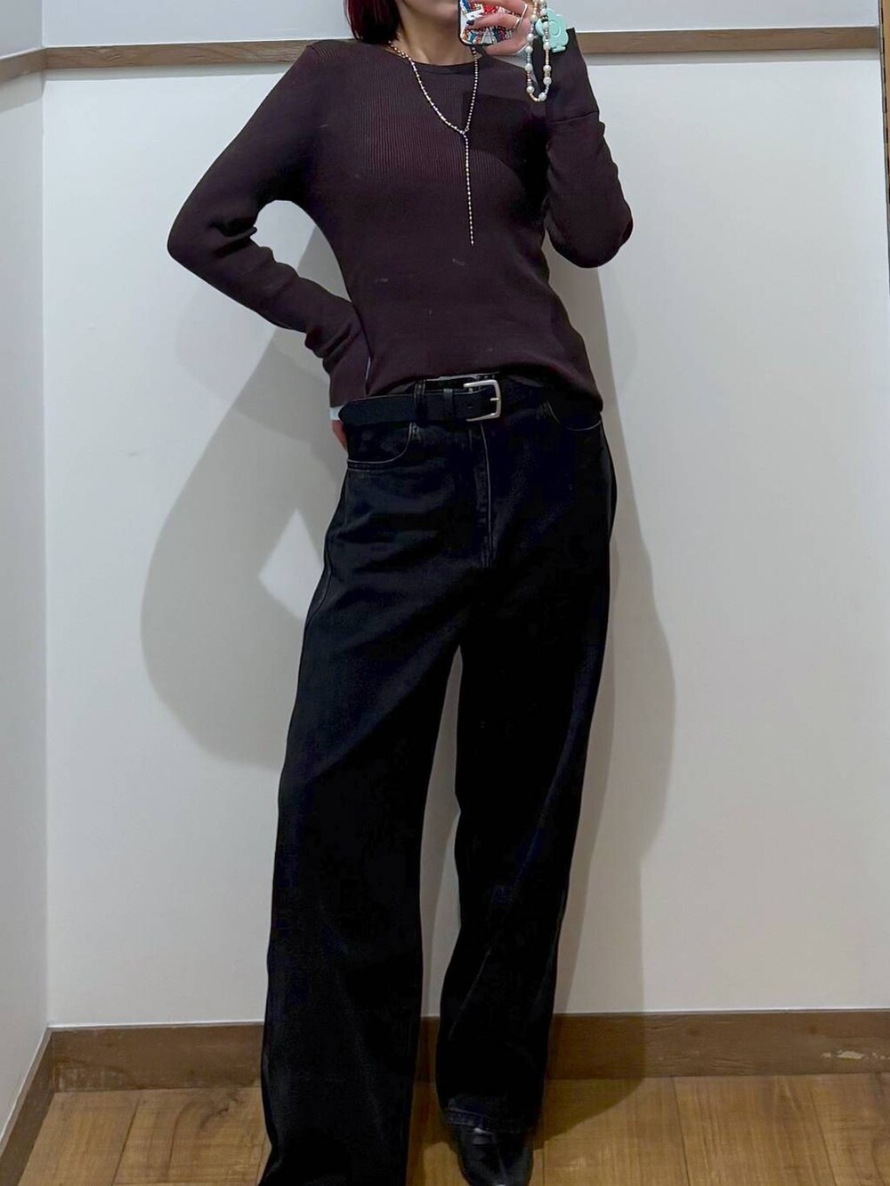 ブラック系のデニムパンツ、ブラック系のブーツ、ブラック系のニット/セーターを着用したレディースの冬コーディネートの2枚目の写真