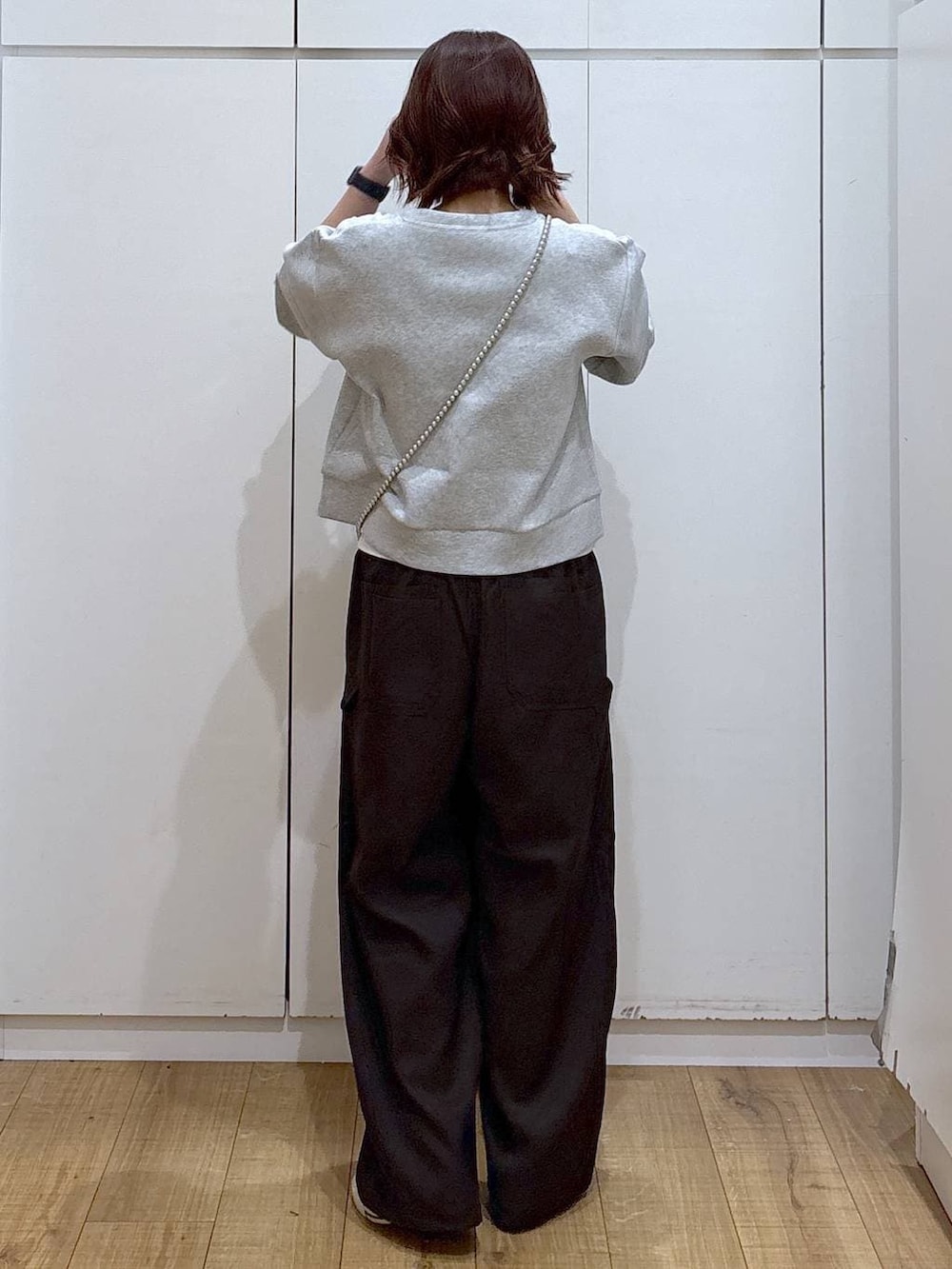 グレー系のカーディガン/ボレロ、ブラウン系のその他パンツ、ホワイト系のタンクトップを着用したレディースの春コーディネートの5枚目の写真