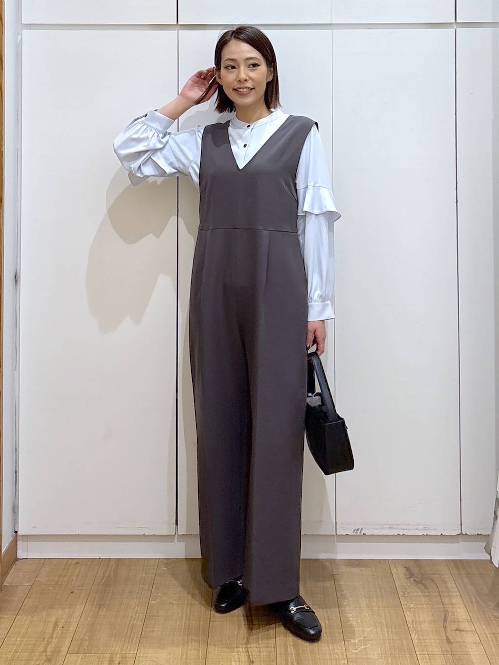 ブラック系のローファー、グレー系のセットアップ、ブラック系のハンドバッグを着用したレディースの冬コーディネートの3枚目の写真