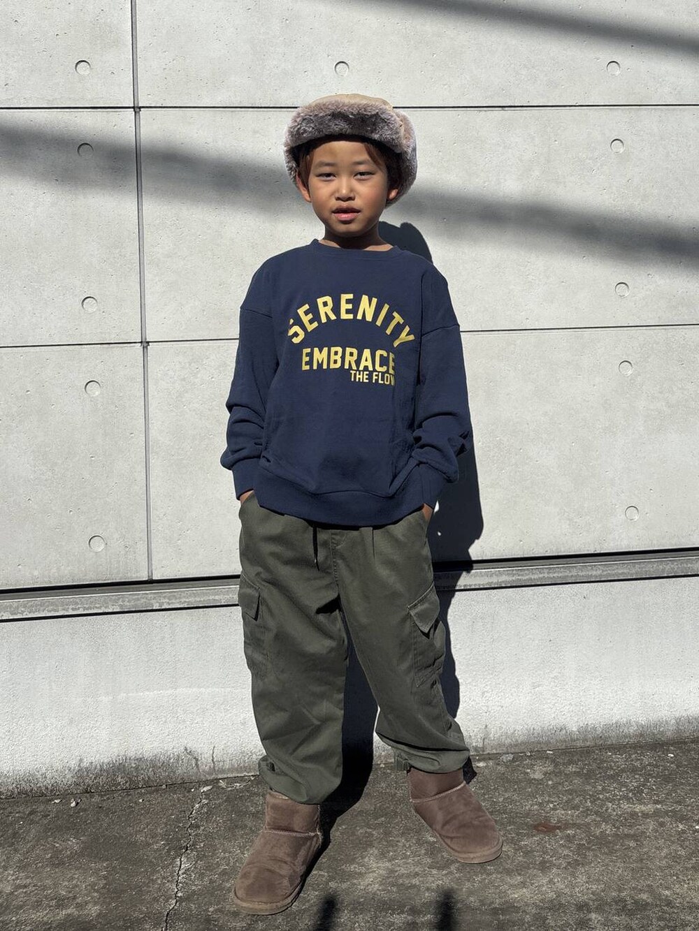 ブルー系のスウェット、グリーン系のカーゴパンツ、ブラウン系のブーツを着用したキッズの秋コーディネートの2枚目の写真
