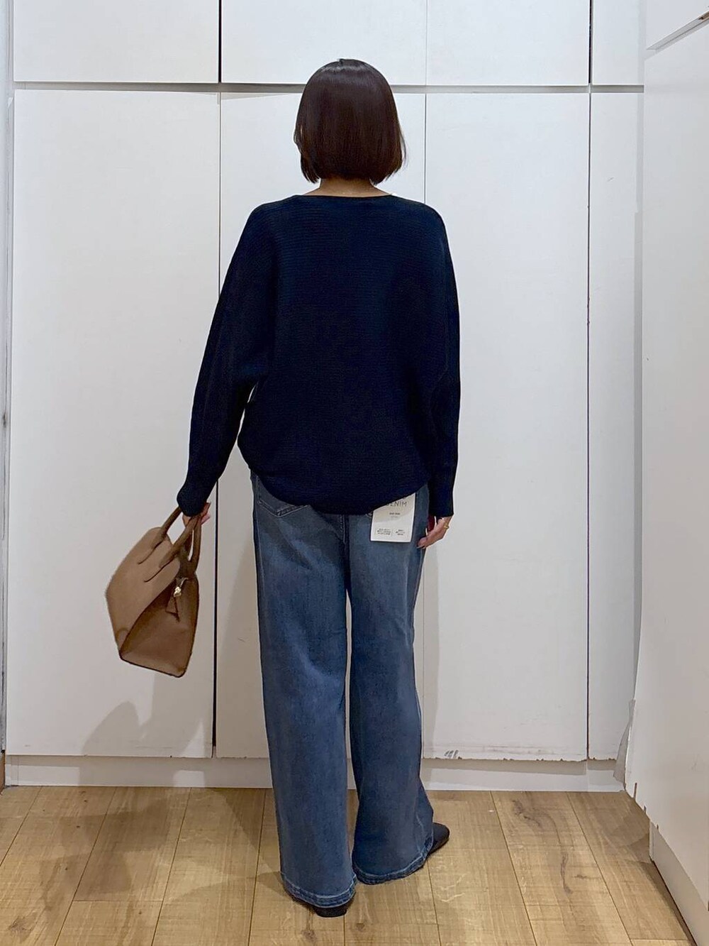 ベージュ系のショルダーバッグ、ブルー系のニット/セーター、ブラック系のブーツを着用したレディースの秋コーディネートの4枚目の写真