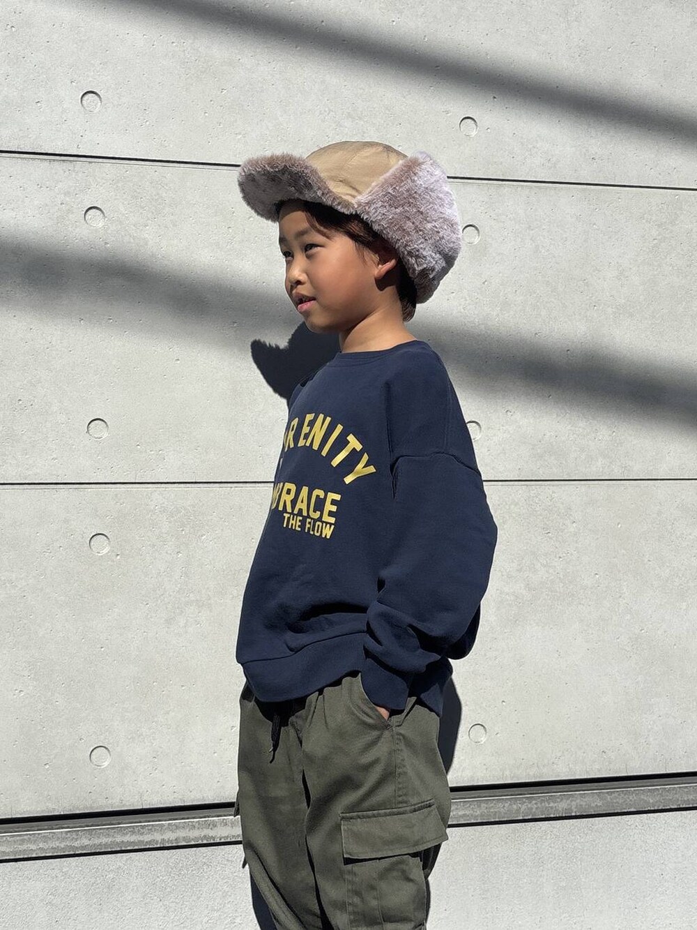 ブルー系のスウェット、グリーン系のカーゴパンツ、ブラウン系のブーツを着用したキッズの秋コーディネートの6枚目の写真