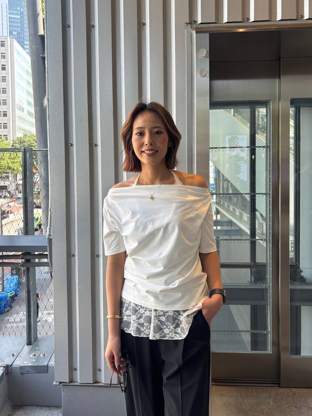 ブラック系のその他パンツ、ブラック系のサンダル、ホワイト系のTシャツ/カットソーを着用したレディースの春コーディネートの7枚目の写真