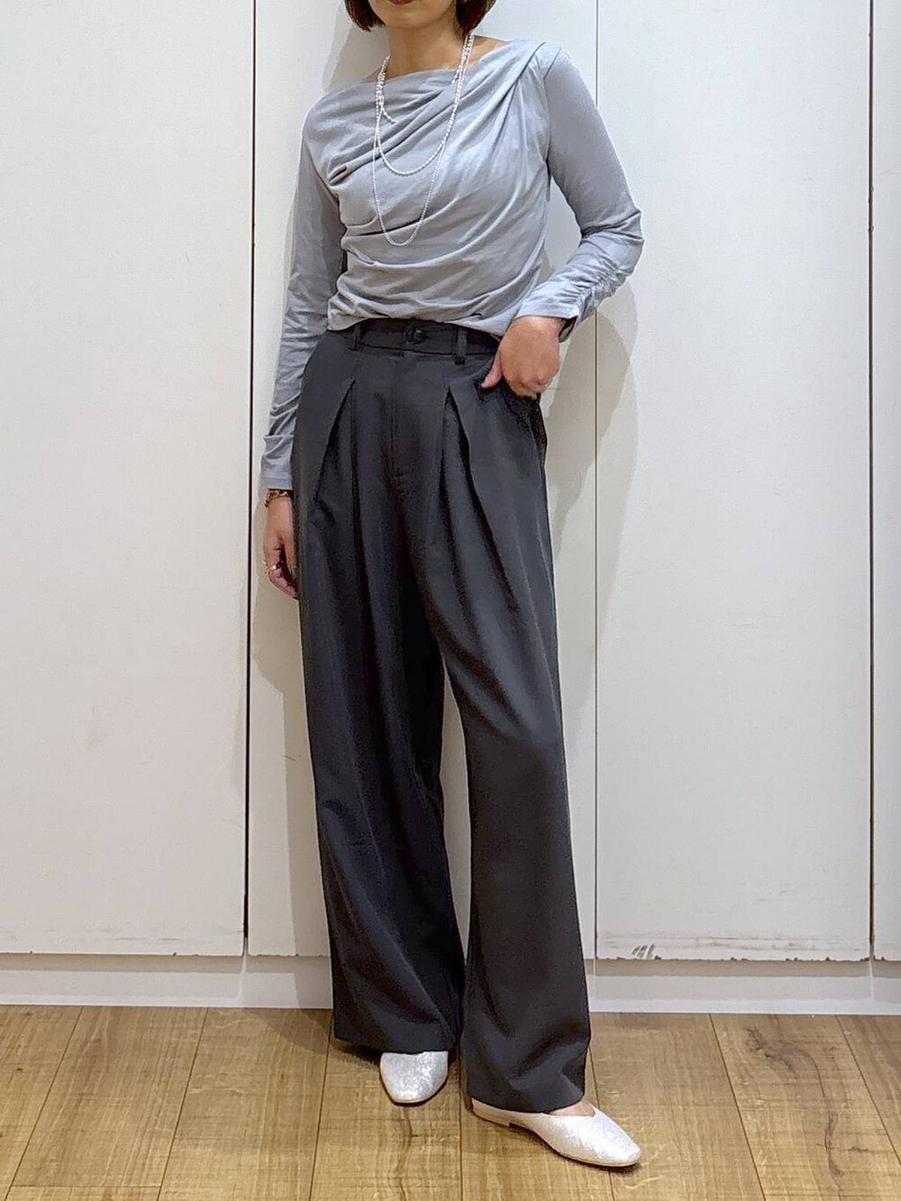 シルバー系のパンプス、グレー系のTシャツ/カットソー、グレー系のスラックスを着用したレディースの秋コーディネートの3枚目の写真