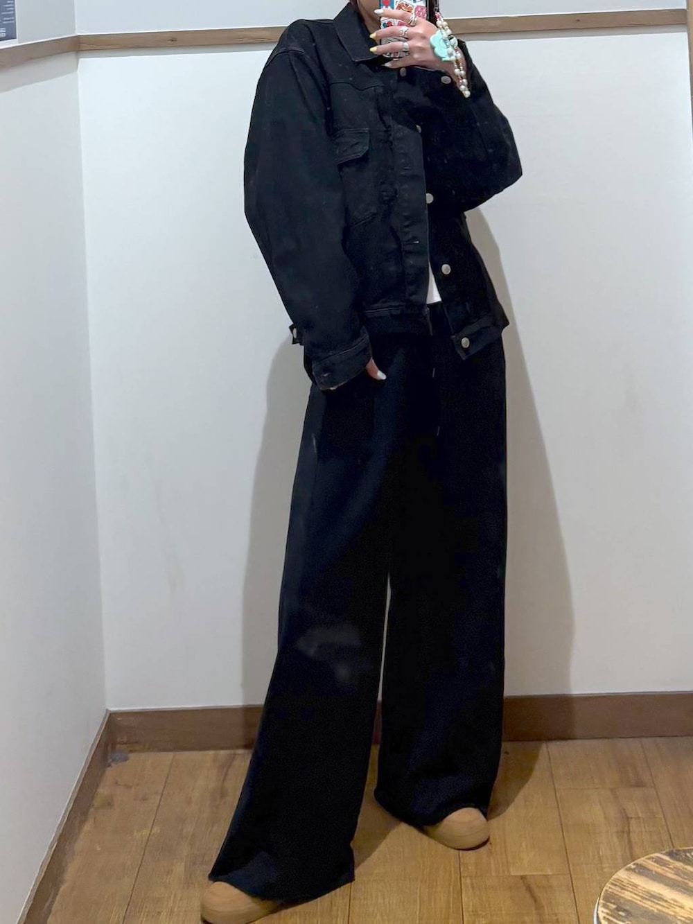 ブラック系のデニムジャケット、ブラック系のスウェットパンツ、ゴールド系のネックレスを着用したレディースの春コーディネートの2枚目の写真