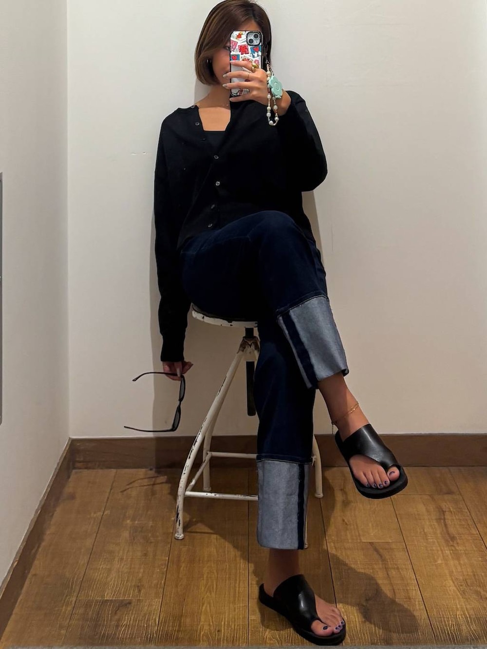 ブルー系のデニムパンツ、ブラック系のキャミソール、ブラック系のカーディガン/ボレロを着用したレディースの秋コーディネートの2枚目の写真