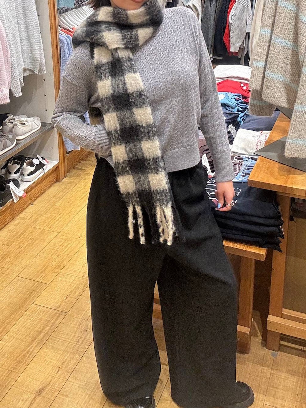 ブラック系のその他パンツ、グレー系のニット/セーター、ブラック系のマフラーを着用したレディースの冬コーディネートの2枚目の写真