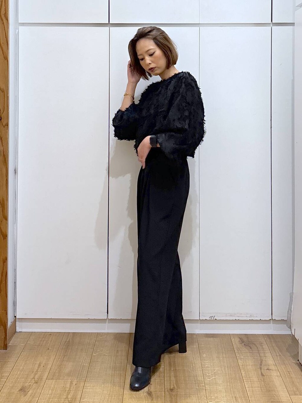 ブラック系のブーツ、ブラック系のシャツ/ブラウス、ブラック系のスラックスを着用したレディースの秋コーディネートの3枚目の写真