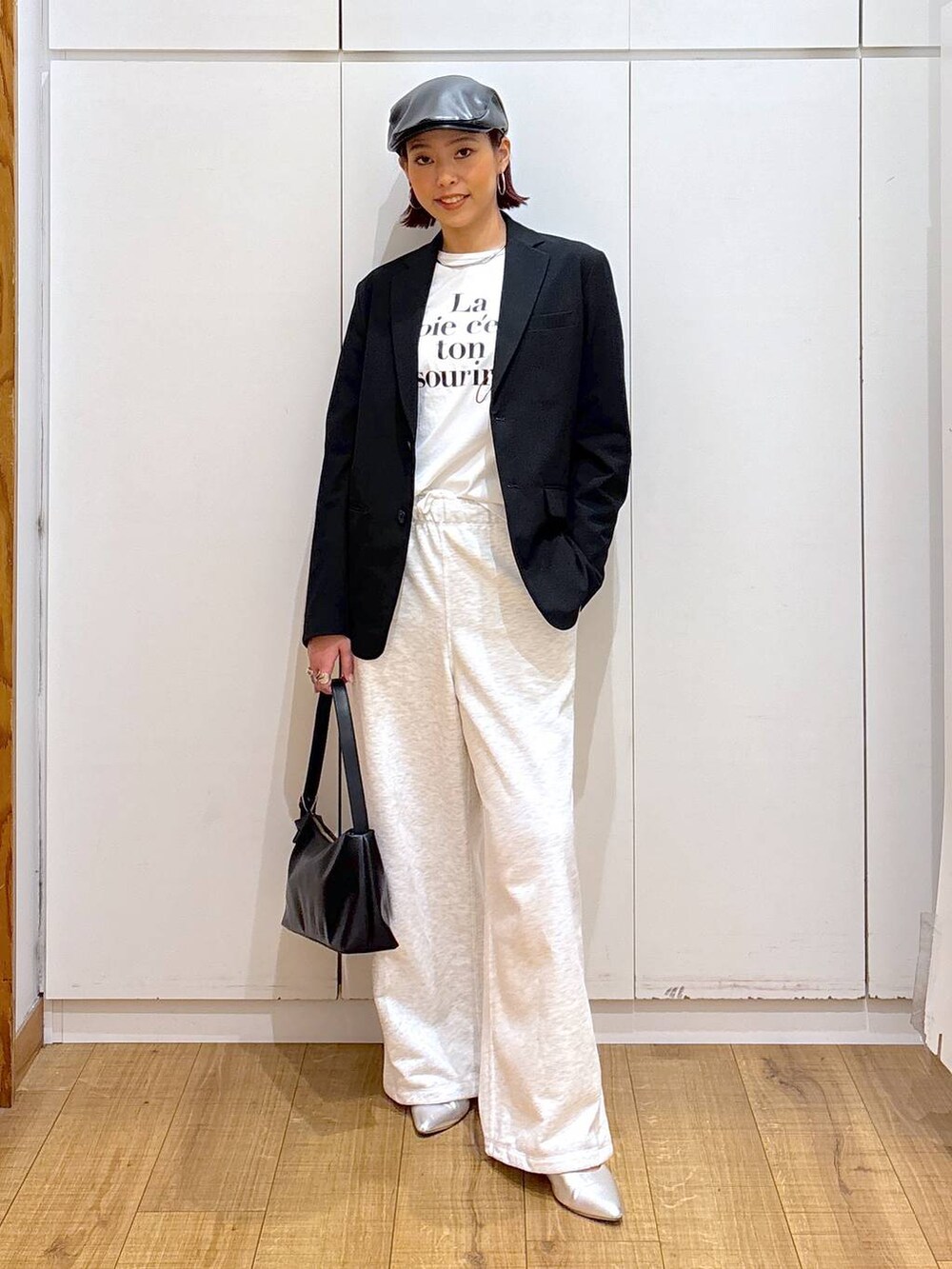 ブラック系のテーラードジャケット、ブラック系のショルダーバッグ、ホワイト系のTシャツ/カットソーを着用したレディースの春コーディネートの2枚目の写真