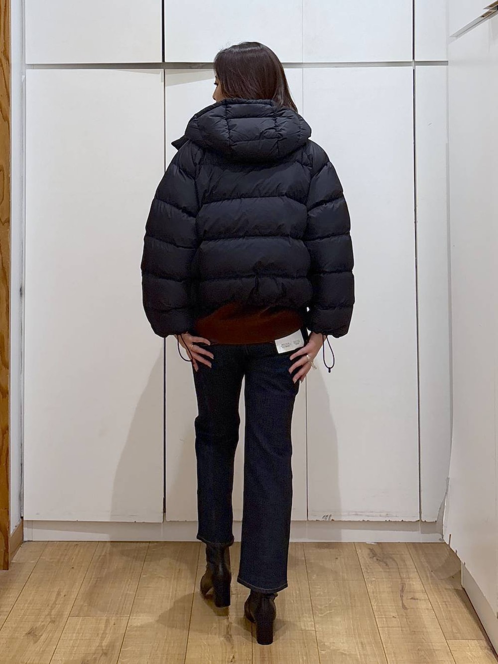 ブルー系のデニムパンツ、ブラウン系のスウェット、ブラック系のブーツを着用したレディースの秋コーディネートの2枚目の写真